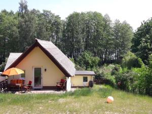 ein kleines Cottage mit einem Strohdach auf einem Feld in der Unterkunft Christianshof Insel Usedom in Stoben