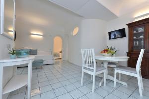 een woonkamer met een tafel en stoelen en een bank bij Villa Gelsomina in Ravello