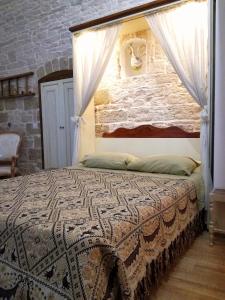 ein Schlafzimmer mit einem Bett mit Ziegelwand in der Unterkunft Oltre le mura b&b in Bitonto