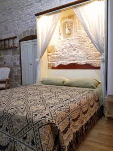 a bedroom with a bed with a brick wall at Oltre le mura b&b in Bitonto