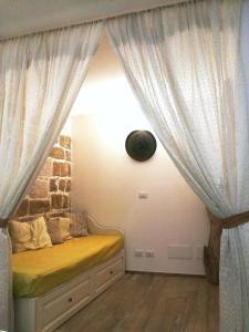Bett in einem Zimmer mit Vorhang in der Unterkunft Oltre le mura b&b in Bitonto