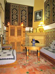 a living room with a table and a fireplace at RIAD Redous in Marrakech