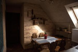 a dining room with a table and a brick wall at Agronoclegi ,,Na Równi" 535-950-405 in Mchawa