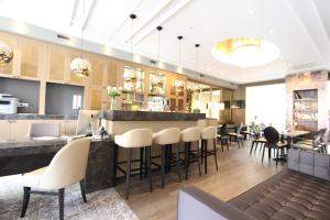 a restaurant with a bar with white chairs and tables at Apple Inn Hotel in Amsterdam