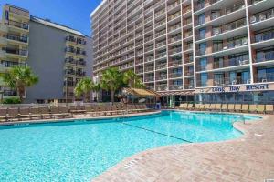 a swimming pool in front of a large building at 453 Shore Fun Oceanfront Great Location in Myrtle Beach