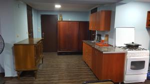 una cucina con armadi in legno e un piano cottura bianco con forno di Binuli House a Kobuleti