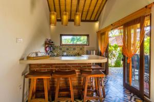 une cuisine avec un comptoir et quelques tabourets dans l'établissement Villa Gayatri Hidden Oasis, à Amed