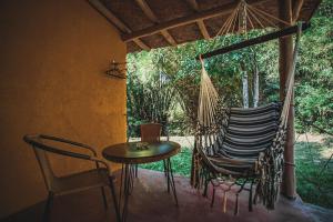 - une terrasse couverte avec un hamac, une table et des chaises dans l'établissement Finca Hostal Bolivar - Casa Maracuya, à Minca