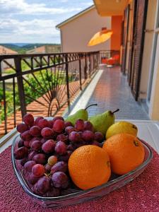 a plate of fruit on a table on a table at Naomi's Sunshine in Cres