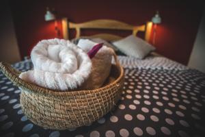 a basket filled with towels sitting on a bed at Finca Hostal Bolivar - Casa Maracuya in Minca