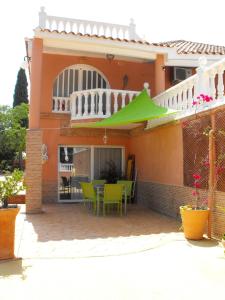a house with a patio with a green umbrella at CASA MARTINEZ Studios & Chambre d'Hôtes à 3 kms de MONTSERRAT VALENCIA in Montroy
