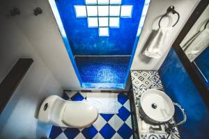 a bathroom with a white sink and a blue shower at Finca Hostal Bolivar - Casa Maracuya in Minca