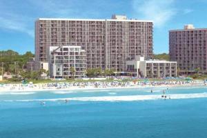 a beach with people in the water and buildings at 453 Shore Fun Oceanfront Great Location in Myrtle Beach