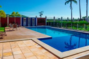 einen Pool im Garten mit Tisch und Stühlen in der Unterkunft Hotel Encosta do Horto in Juazeiro do Norte