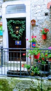 uma porta com uma coroa de flores com vasos de plantas em IL Vicoletto em Serra San Bruno