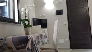 a room with a table with a vase of flowers on it at Case Vacanza Tony in Calatabiano
