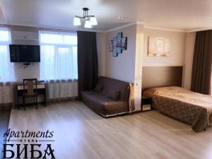 マイコープにあるBiba Apartmentsのベッドルーム(ベッド1台、ソファ、テレビ付)