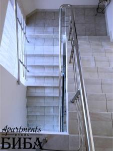 マイコープにあるBiba Apartmentsの建物内のガラス製の手すり付き階段