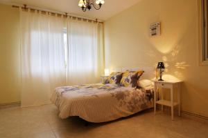 1 dormitorio con 1 cama y 1 mesa con lámpara en La Peñita by #cherrygredos en El Arenal