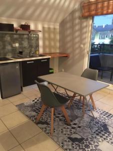 a kitchen with a table and chairs in a kitchen at Studio Bis Cocoon in Saint-Gilles les Bains