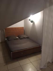 a small bed in a room with a light at Studio Bis Cocoon in Saint-Gilles les Bains