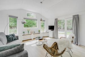 a white living room with a couch and a table at Chalet Descansar op de Veluwe in Beekbergen