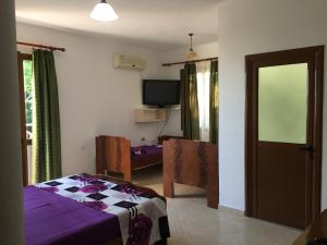 1 dormitorio con 1 cama, TV y mesa en Hotel Moris, en Durrës