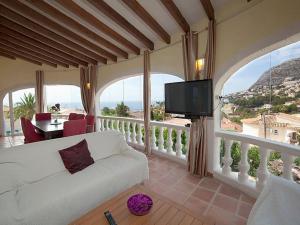 un salon avec un canapé blanc et une télévision dans l'établissement villa Belucra,10p,seaview,jacuzzi,pool, à Calp