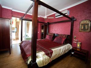 - une chambre avec un lit à baldaquin et des murs rouges dans l'établissement villa Belucra,10p,seaview,jacuzzi,pool, à Calp 29 autres photos