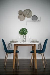 a dining room table with two chairs and a plant at Presso Pécs in Pécs
