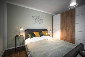 1 dormitorio con 1 cama grande con almohadas amarillas en Presso Pécs, en Pécs