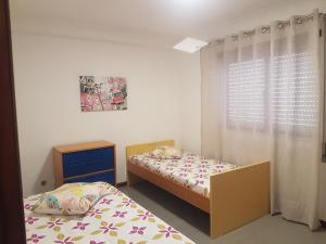 two twin beds in a room with a window at Beach and Mountain Paradise in Vila Praia de Âncora