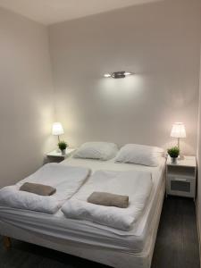 Una cama blanca con dos almohadas encima. en Silver Garden, en Siófok