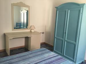 カーラゴノネにあるappartamento Oleandroの青いキャビネットと鏡付きのドレッシングルーム