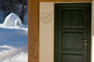 a door to a house with snow behind it at Chalet Presanella in Temù +37 photos