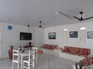 ein Wohnzimmer mit einem Sofa und einem TV an der Wand in der Unterkunft Pousada Pé de Caju in Alcobaça