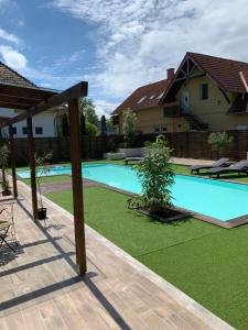 a swimming pool in a backyard with a lawn at Silver Lounge Siófok in Siófok