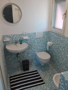bagno con lavandino, servizi igienici e specchio di Casa Greta a Lerici