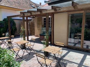 a patio with tables and chairs on a patio at Silver Lounge Siófok in Siófok