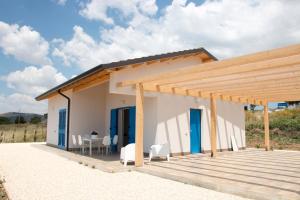 a small white house with a wooden deck at Casa Collis in San Leone