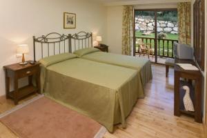 a bedroom with a large bed and a balcony at Posada Mar de Santillana in Ubiarco