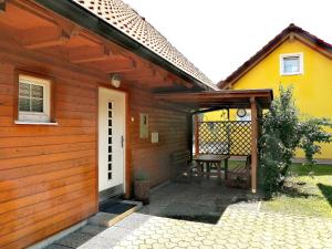 una casa de madera con una mesa de picnic delante de ella en Bella Mura Nature House I26, en Podčetrtek