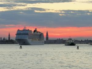 een cruiseschip in het water bij zonsondergang bij Via Cipro 16 in Venetië-Lido