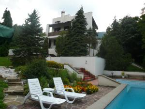 two chairs and a swimming pool in front of a house at Мечтаната селска къща на реката със семейство и приятели! in Ribarica