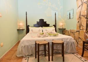 een slaapkamer met een groot bed met 2 krukken bij Fiori e Coccole in Noto