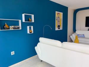 een woonkamer met een witte bank en blauwe muren bij Bingo in Omiš