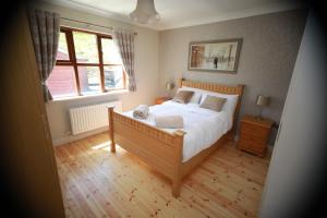 Un dormitorio con una cama grande y una ventana en Alices Loft & Cottages, en Castleblayney