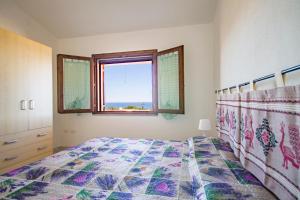 een slaapkamer met een bed en een raam bij CASA VITALIA- SUPER Vista Mare-2 camere -Giardino-BBQ - WiFi FREE-Parcheggio IUNP5732 in Torre Dei Corsari