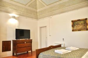a bedroom with two beds and a flat screen tv at Casa Turi in Alberobello