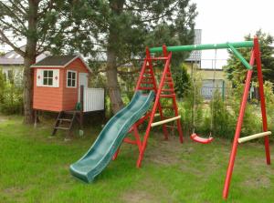 a playground with a slide and a play house at Apartament Klaudia in Sarbinowo